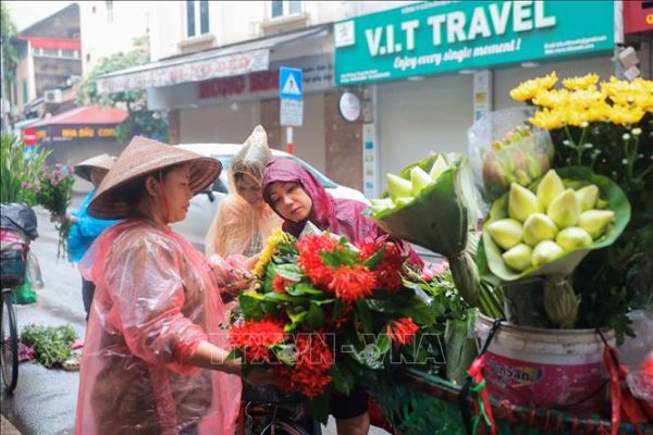 Người dân Hà Nội đội mưa đi mua sắm trong Tết Đoan Ngọ- Ảnh 1.