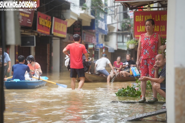 Nước rút dần, người dân ở 'rốn lũ' Hoàn Kiếm tất bật dọn dẹp, chở đồ đạc về nhà- Ảnh 1.